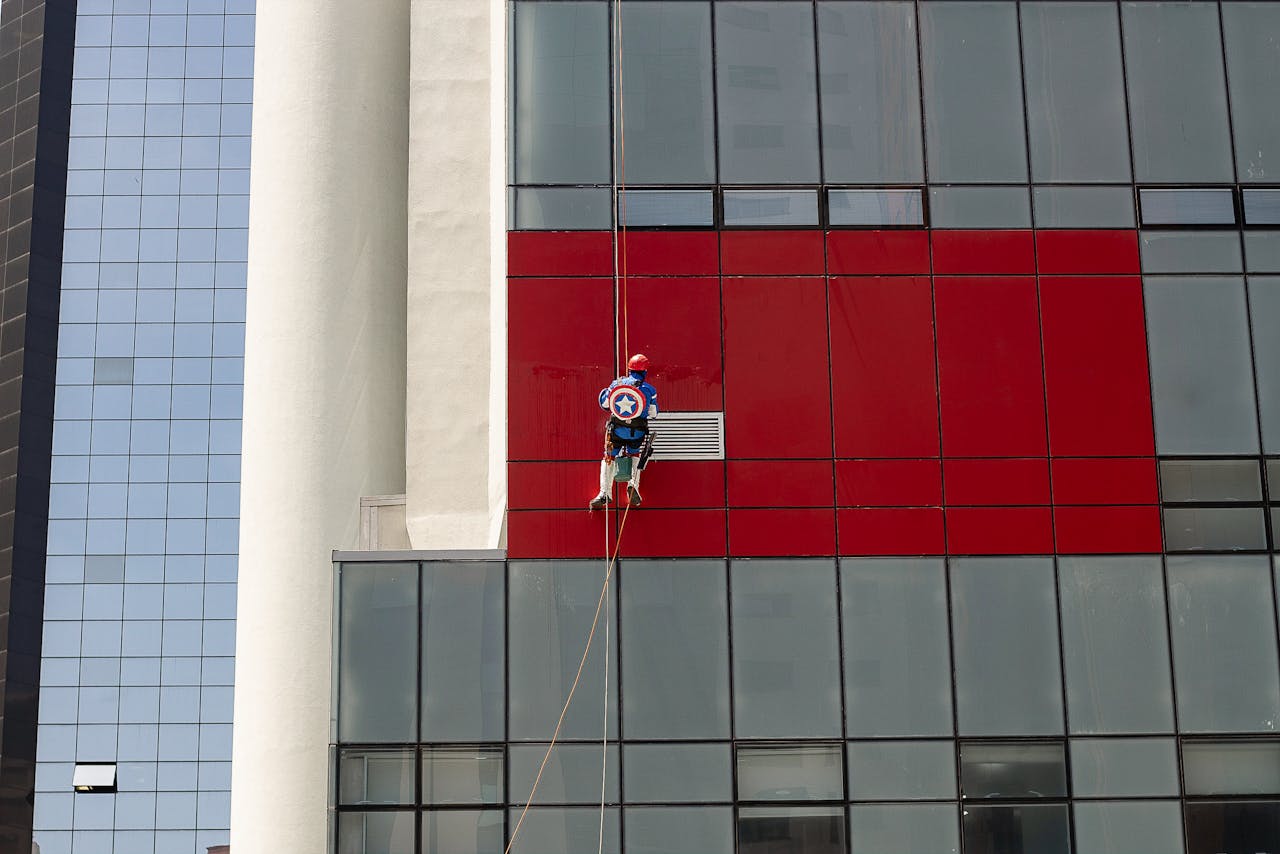 A window cleaner dressed as a superhero cleans a skyscraper in São Paulo, creating a unique urban scene.